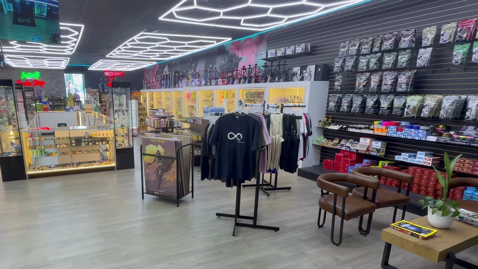 The sales floor at Infinity Smoke Shop, with lit glass cases and hexagon ceiling lights
